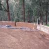 Sections of curved rammed earth begin to form the outdoor feature wall