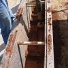 Use oil operated hand rammers to compact a layer of soil within formwork